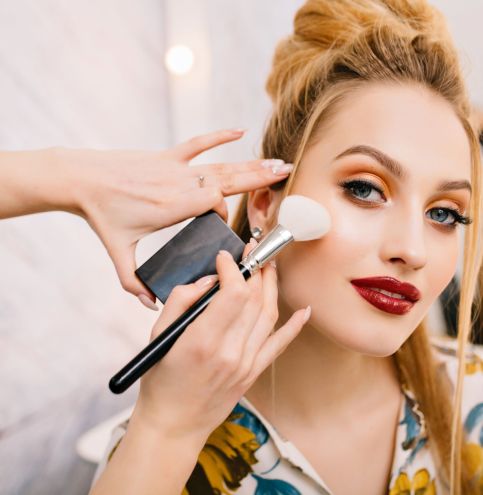 Preparing to party, carnival, celebration of attractive young women in beauty salon. Making makeup, stylish coiffure, professional stylist, cheerful mood, fashionable model